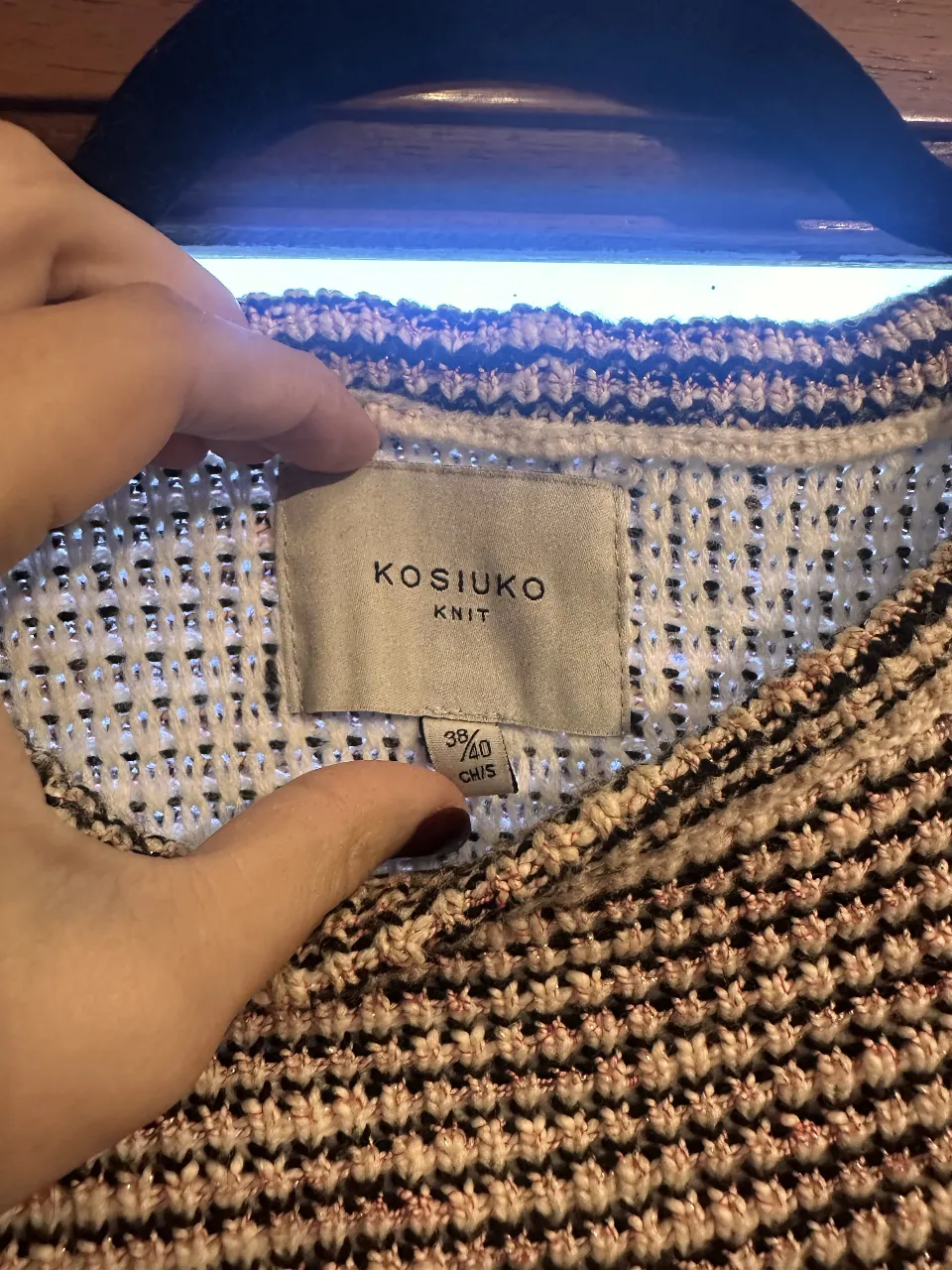Sweater de punto Kosiuko para mujer, con diseño a rayas en blanco y negro. Cuello redondo y detalles de botones dorados en los hombros. Ideal para un look casual y moderno.