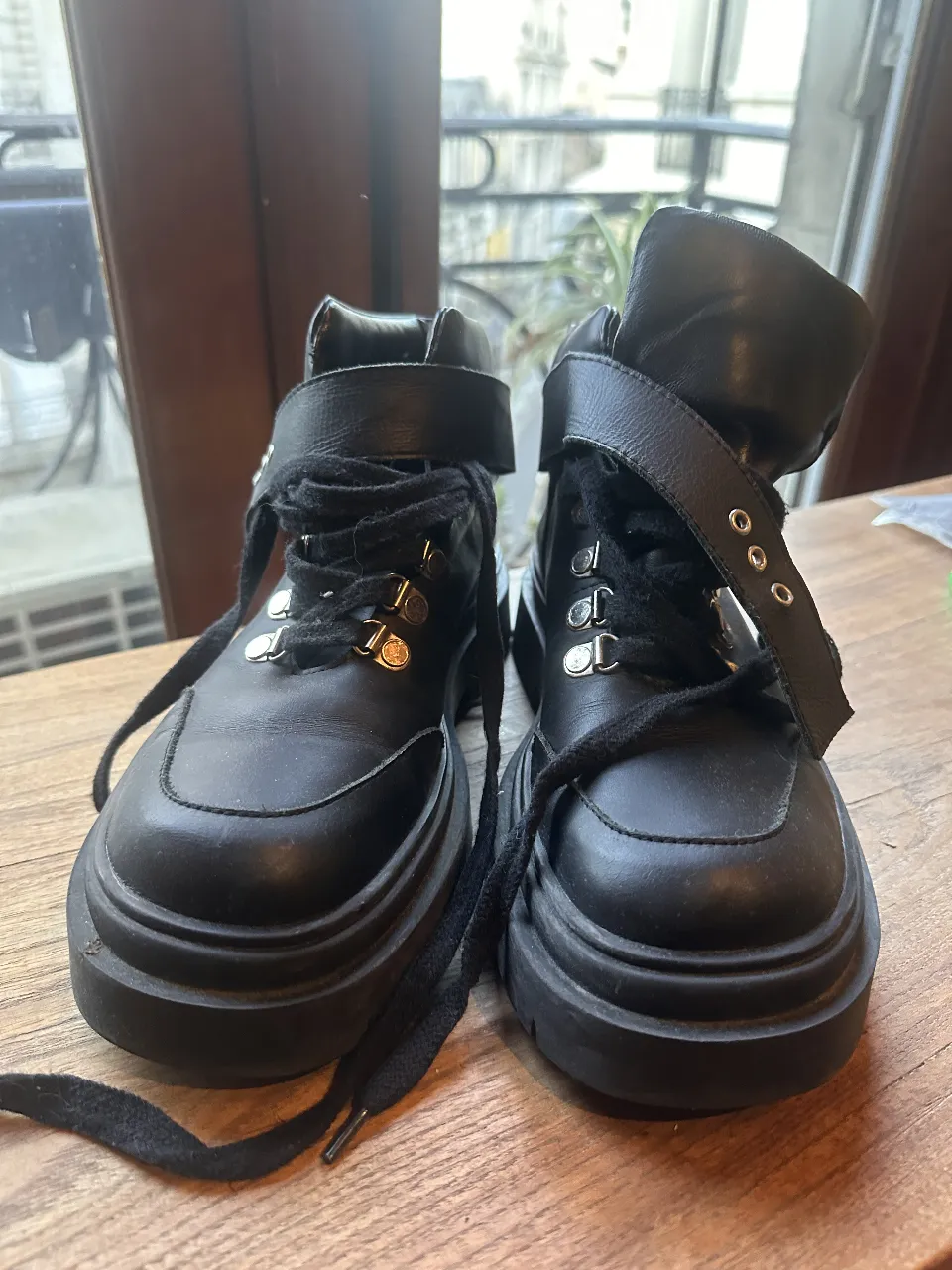 Borcegos negros con detalles de hebillas y cordones. Ideales para un look urbano y moderno.