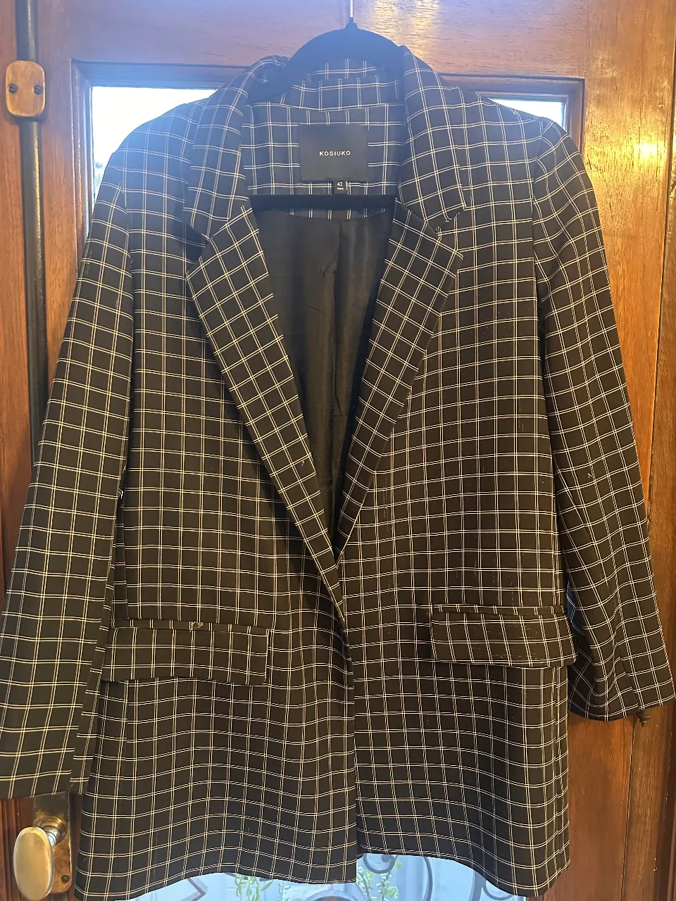 Blazer a cuadros negro y blanco de la marca Kosiuko, ideal para un look elegante y moderno. Perfecto para combinar con diferentes outfits.