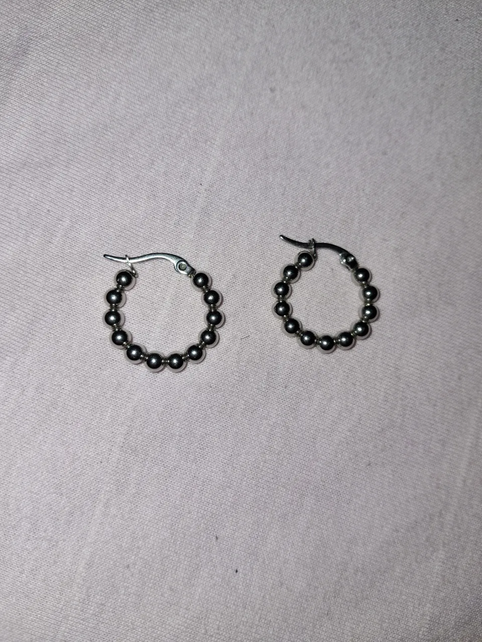 Aros argolla plateados con cuentas redondas.