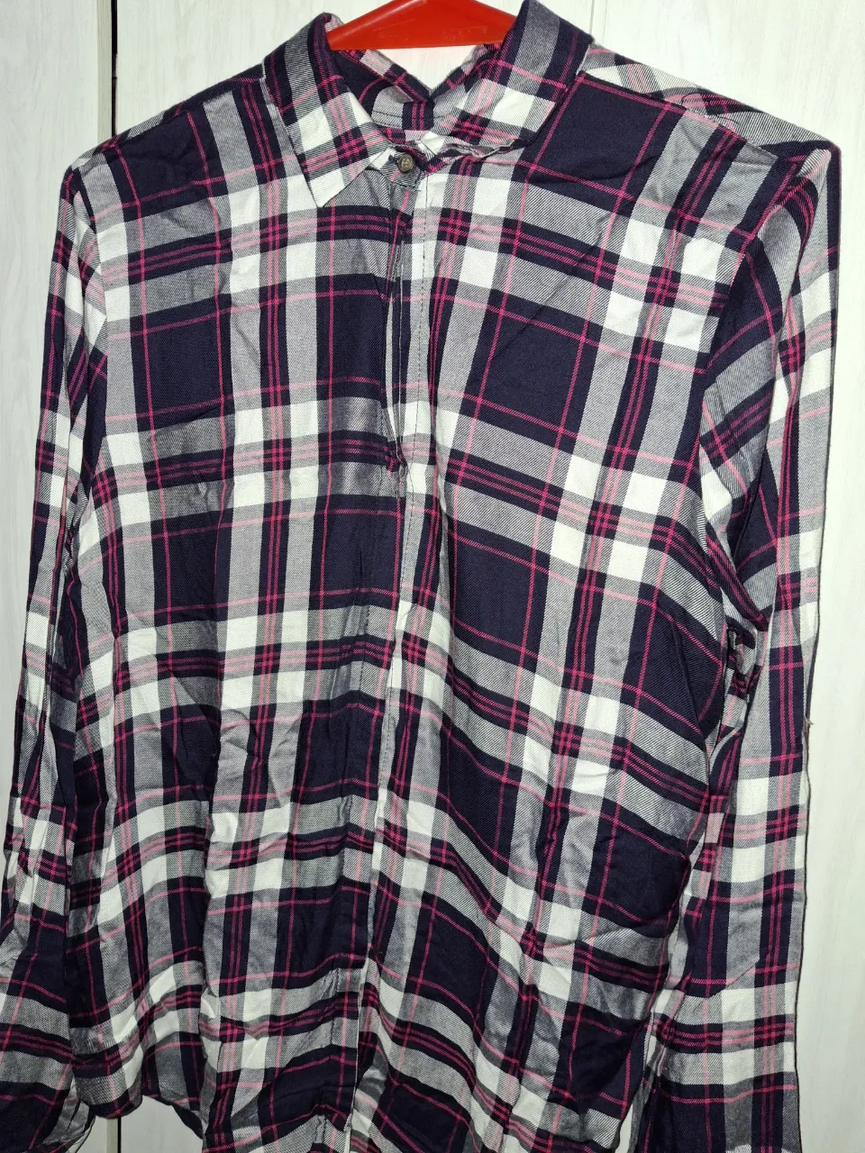 Camisa a cuadros de manga larga con botones al frente. Cuello camisero.
