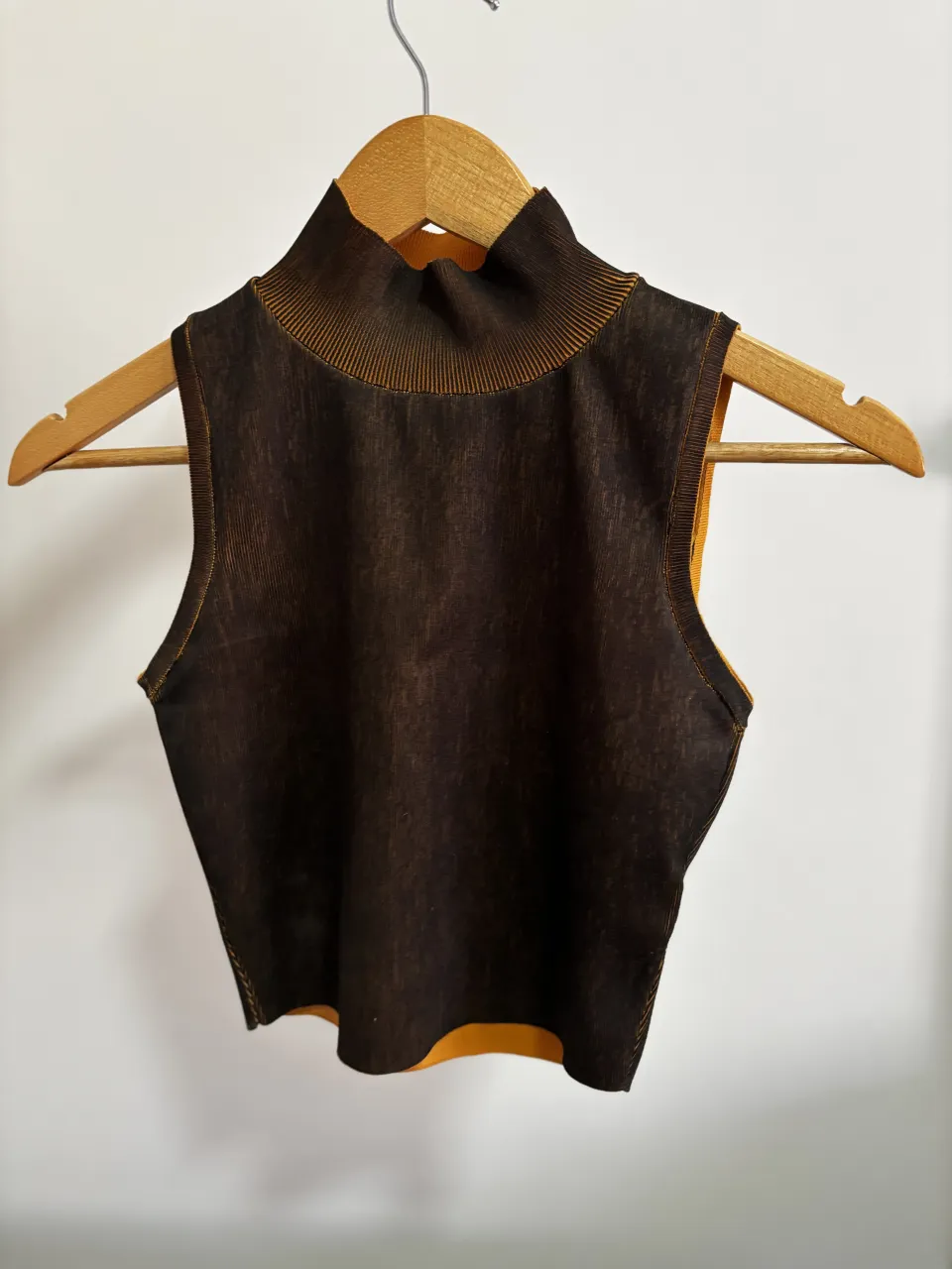 Top Zara sin mangas de cuello alto con textura acanalada .El color principal es marrón oscuro con detalles en amarillo ocre/naranja
casi sin uso, impecable 