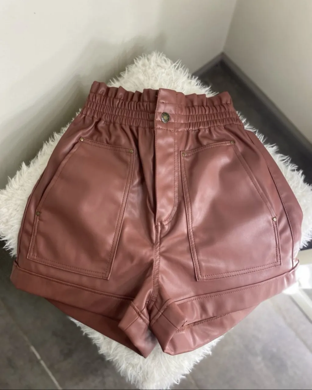 Shorts Zara de cuero sintético con cintura elastizada y detalle de fruncido. Posee bolsillos delanteros y traseros con tapa y botón.
color ladrillo 