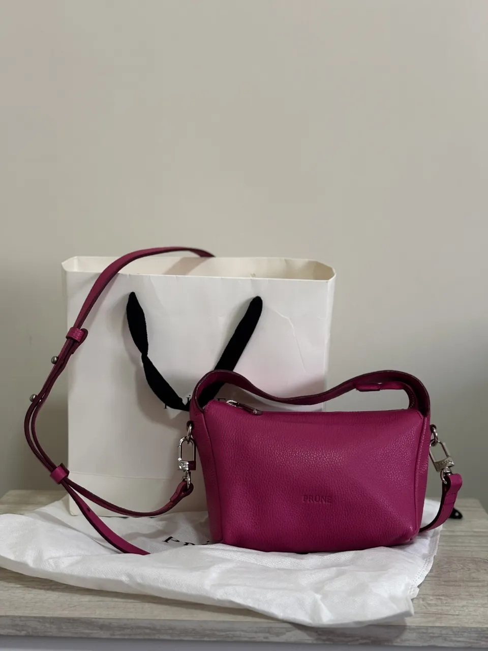 Carte Prune de cuero color fucsia/rosa oscuro con correa larga regulable y manijas cortas. Cierre superior. casi sin uso, impecable, siempre guardado con doble bolsa y relleno 