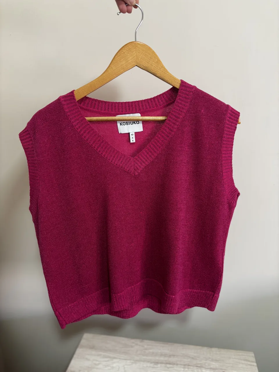 Chaleco tejido Kosiuko, color fucsia con brillos sutiles. Escote en V y cuello acanalado.
es finito, esta en excelente estado