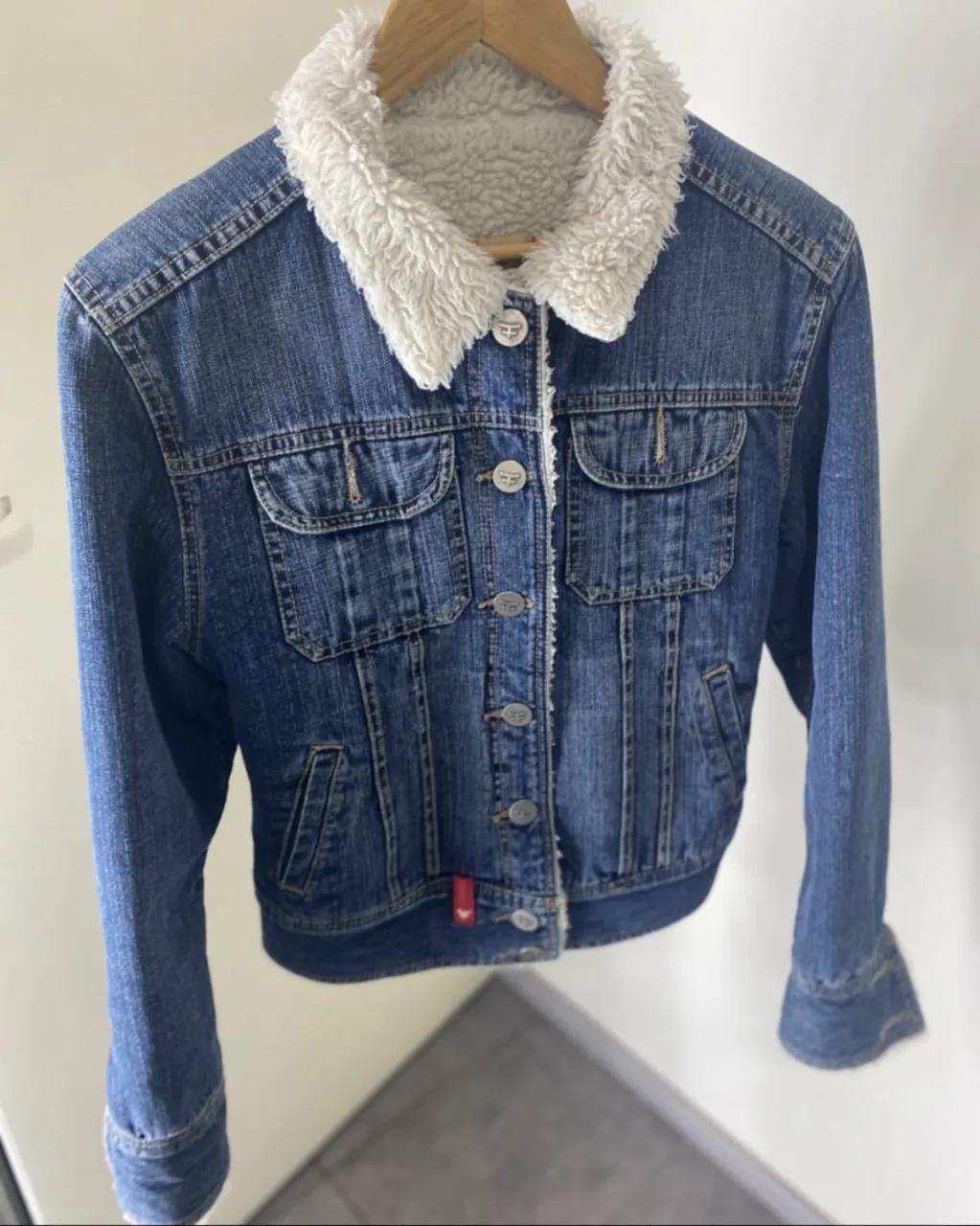 Campera Kosiuko de jean azul con interior de corderito blanco. Tiene botones al frente y en los bolsillos. es entallada 
