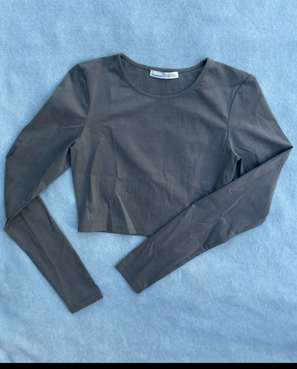 Top manga larga de color gris, de la marca Pull&Bear, ideal para un look casual y cómodo.