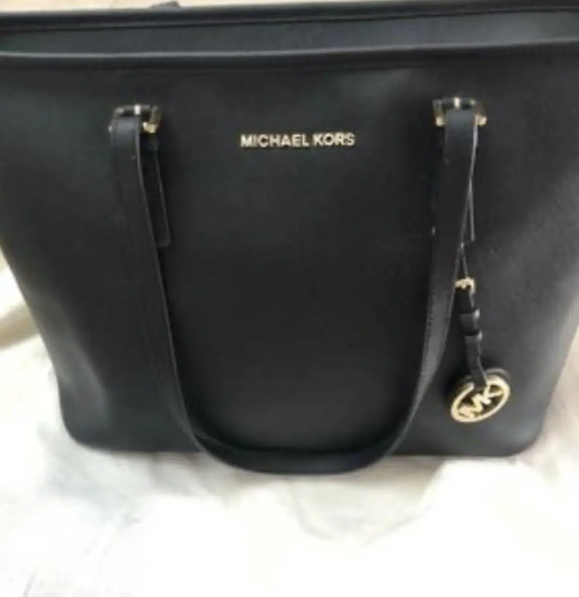 Cartera Michael Kors negra, modelo tote bag, con detalles dorados y dije con el logo de la marca. Ideal para llevar todo lo necesario con estilo. original nueva con etiqueta ideal facultad 