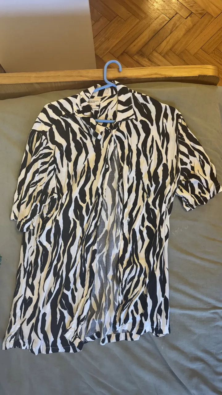 Camisa estampada con diseño de cebra, manga corta y cuello camisero. Ideal para un look canchero y moderno.