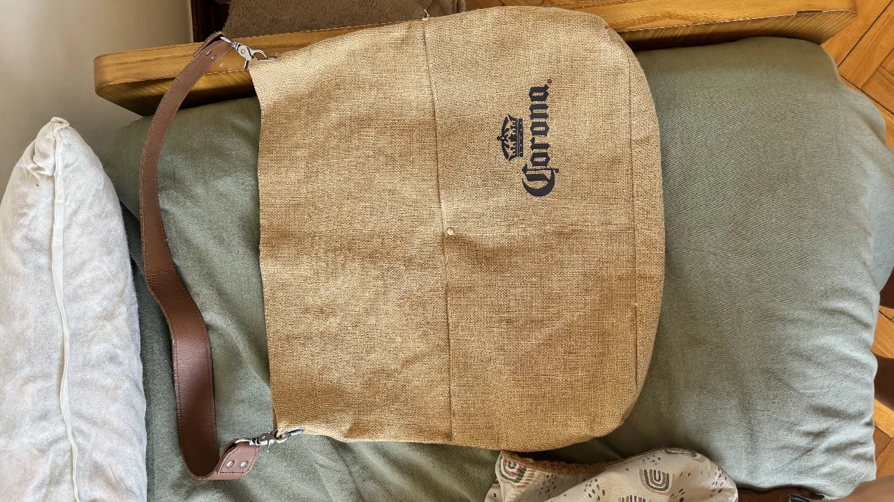 Bolso de tela tipo playero, ideal para llevar todo lo necesario a la playa o para el día a día. Su diseño rústico y el logo de Corona le dan un toque canchero y relajado. Perfecto para un look casual y veraniego.