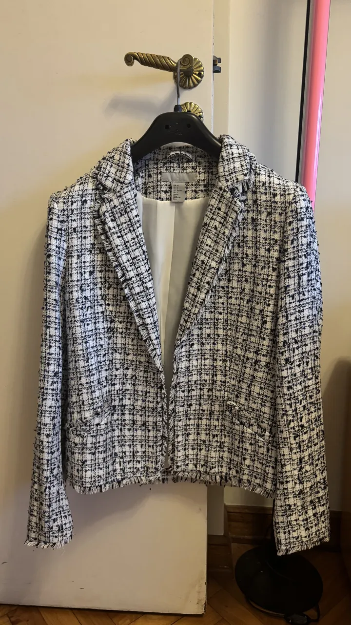 Blazer tweed blanco y negro con detalles desflecados en puños y ruedo. Ideal para un look elegante y moderno. EU34 US4