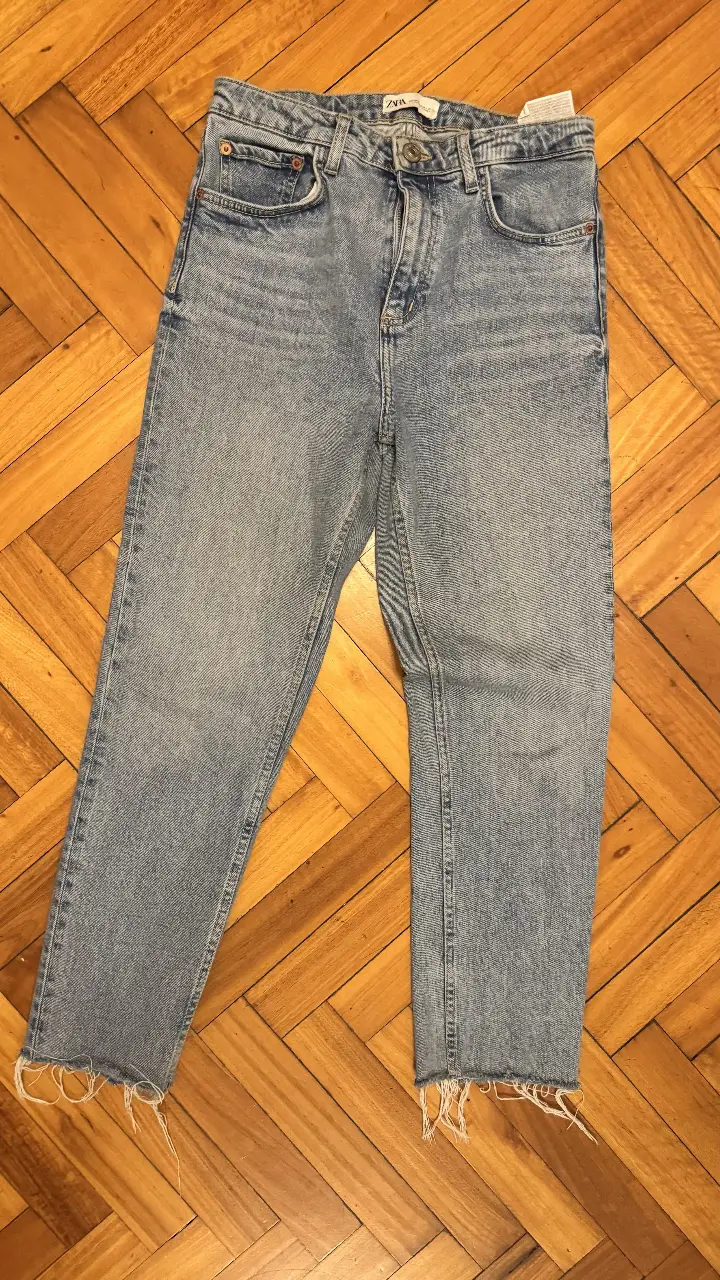 Jeans rectos de mujer, tiro medio, con roturas en los bajos. Marca Zara, talle 40.