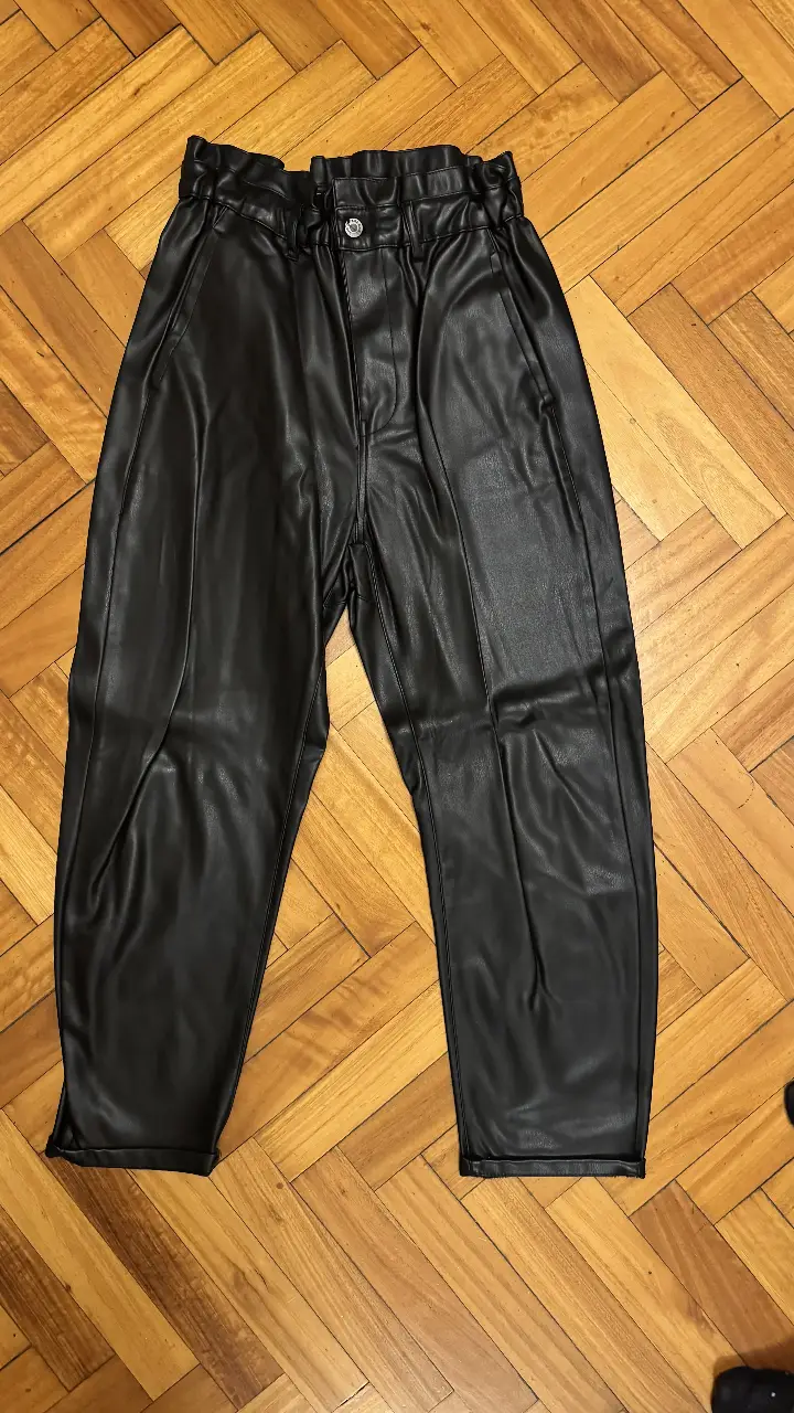 Pantalón de cuero sintético negro de Zara, con cintura elastizada y bolsillos. Ideal para un look moderno y cómodo.