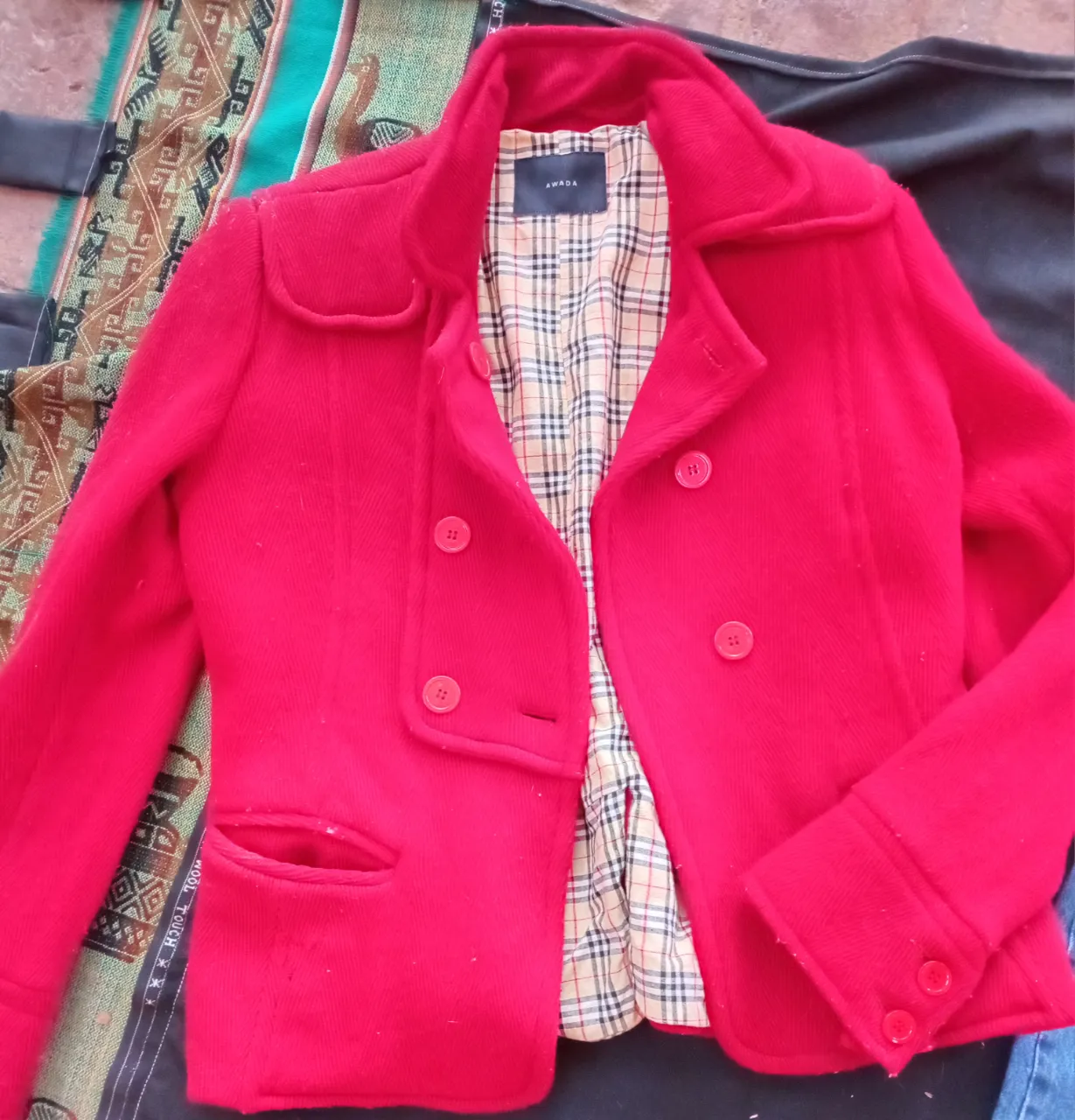 Chaqueta roja de mujer, estilo blazer, con forro interior a cuadros. Ideal para un look elegante y sofisticado.