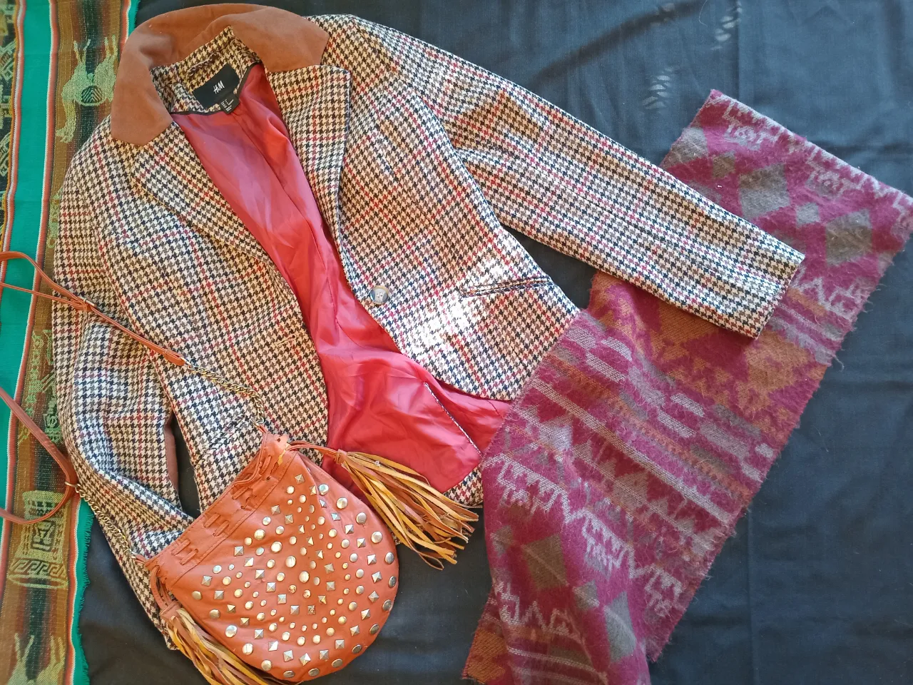 Blazer de mujer con estampado de cuadros en tonos marrones y rojos. Cuello de pana marrón y forro interior rojo. Ideal para un look vintage y elegante.
