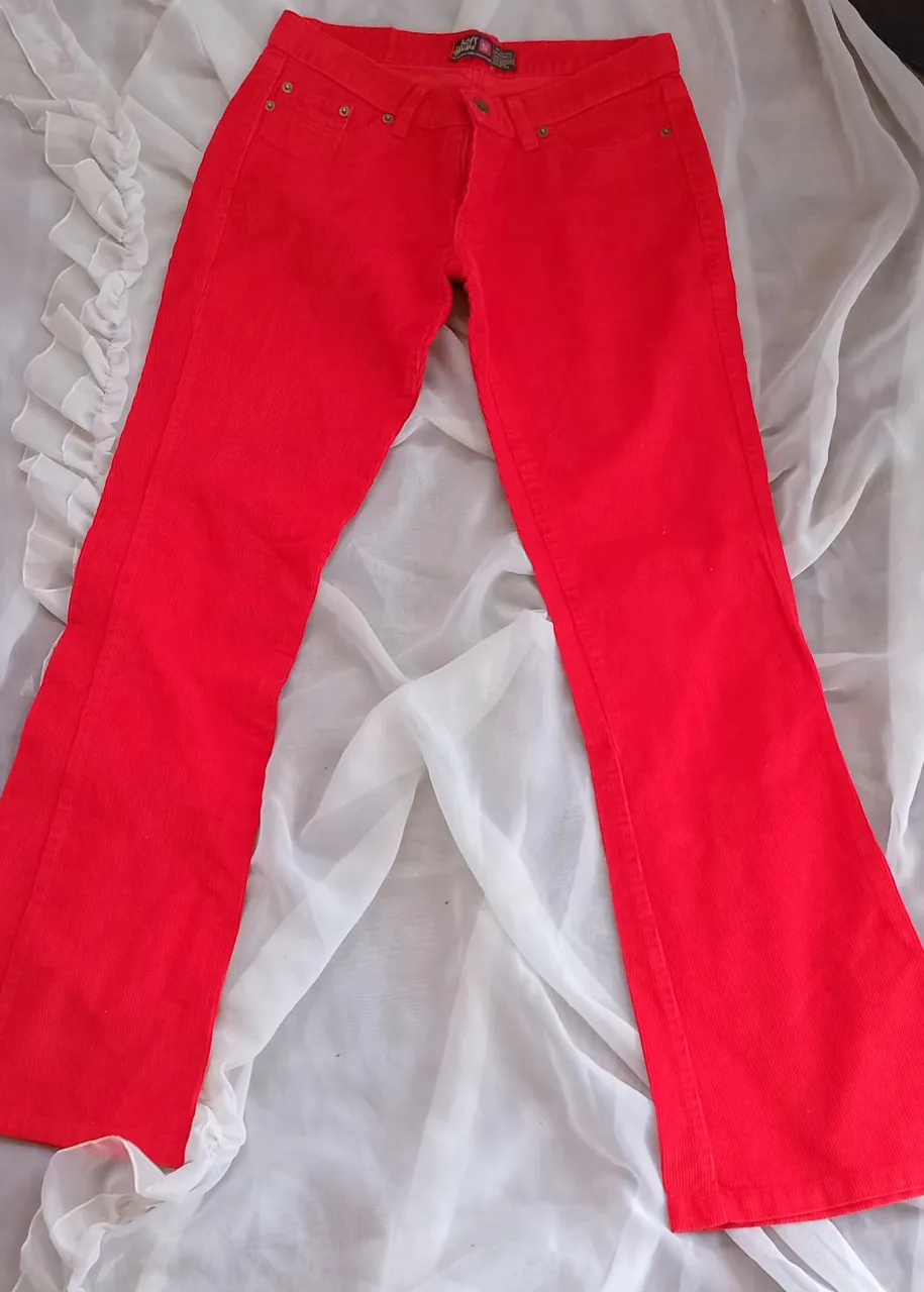 Pantalón de corderoy rojo, tiro medio, corte recto y bota ancha. Ideal para un look casual y cómodo.