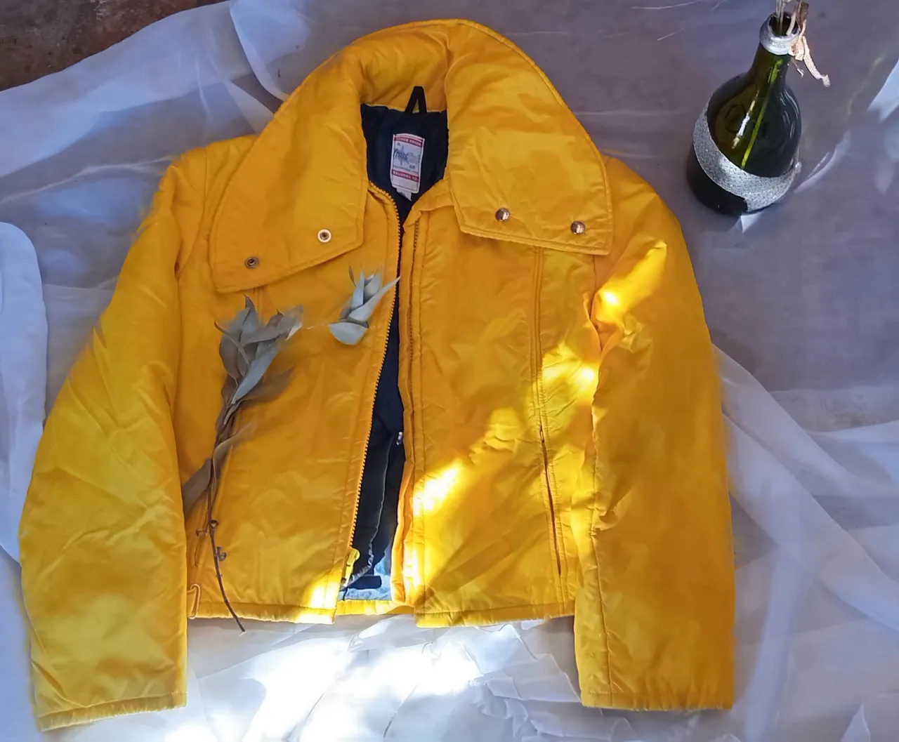Campera bomber amarilla con cuello alto y cierre. Interior azul. Ideal para un look retro y canchero.
