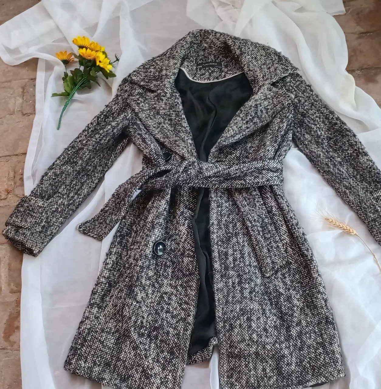 Tapado largo de paño para mujer, con diseño de espiga en tonos grises y negros. Incluye cinturón para ajustar la cintura y botones 