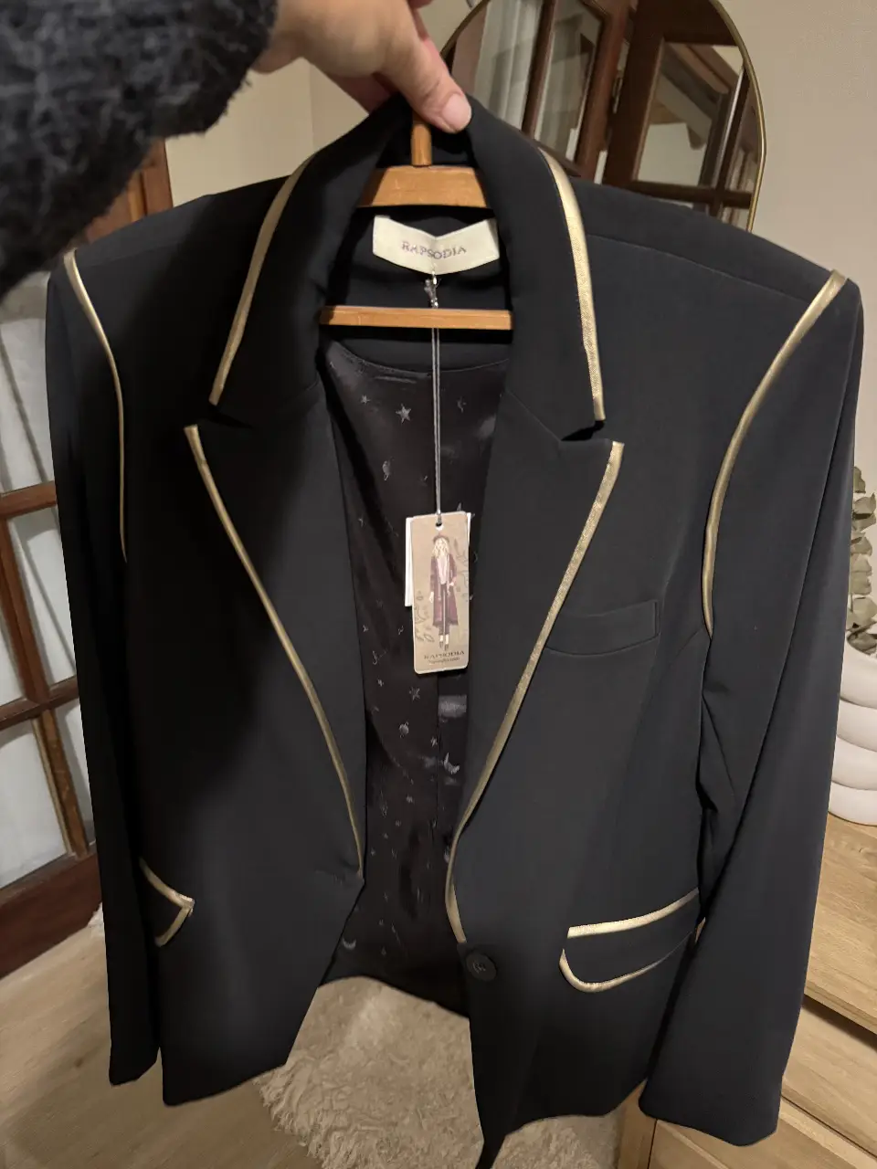 Elegante blazer negro con detalles dorados. Ideal para un look formal o de fiesta. Confeccionado con materiales de alta calidad, este blazer es una prenda atemporal que no puede faltar en tu guardarropa.