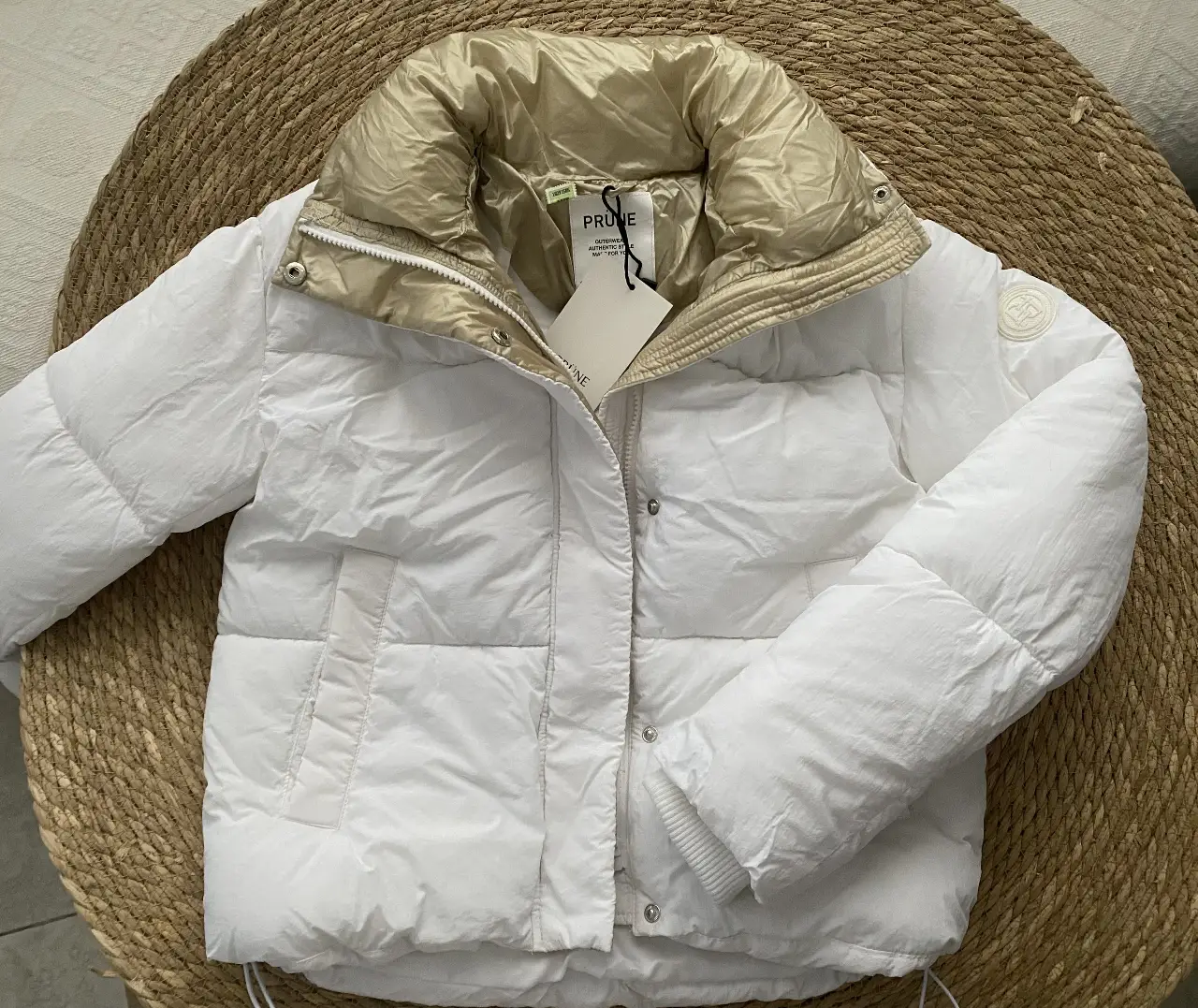 Campera Puffer PRUNE, color blanco con cuello dorado. Ideal para el invierno, abrigo y estilo en una sola prenda. Perfecta para un look casual y moderno.
