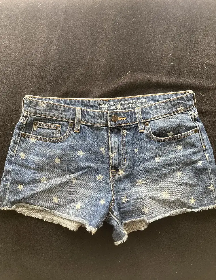 Short de jean de mujer, tiro medio, con estampado de estrellas blancas. Marca Gap, estilo sexy boyfriend.
