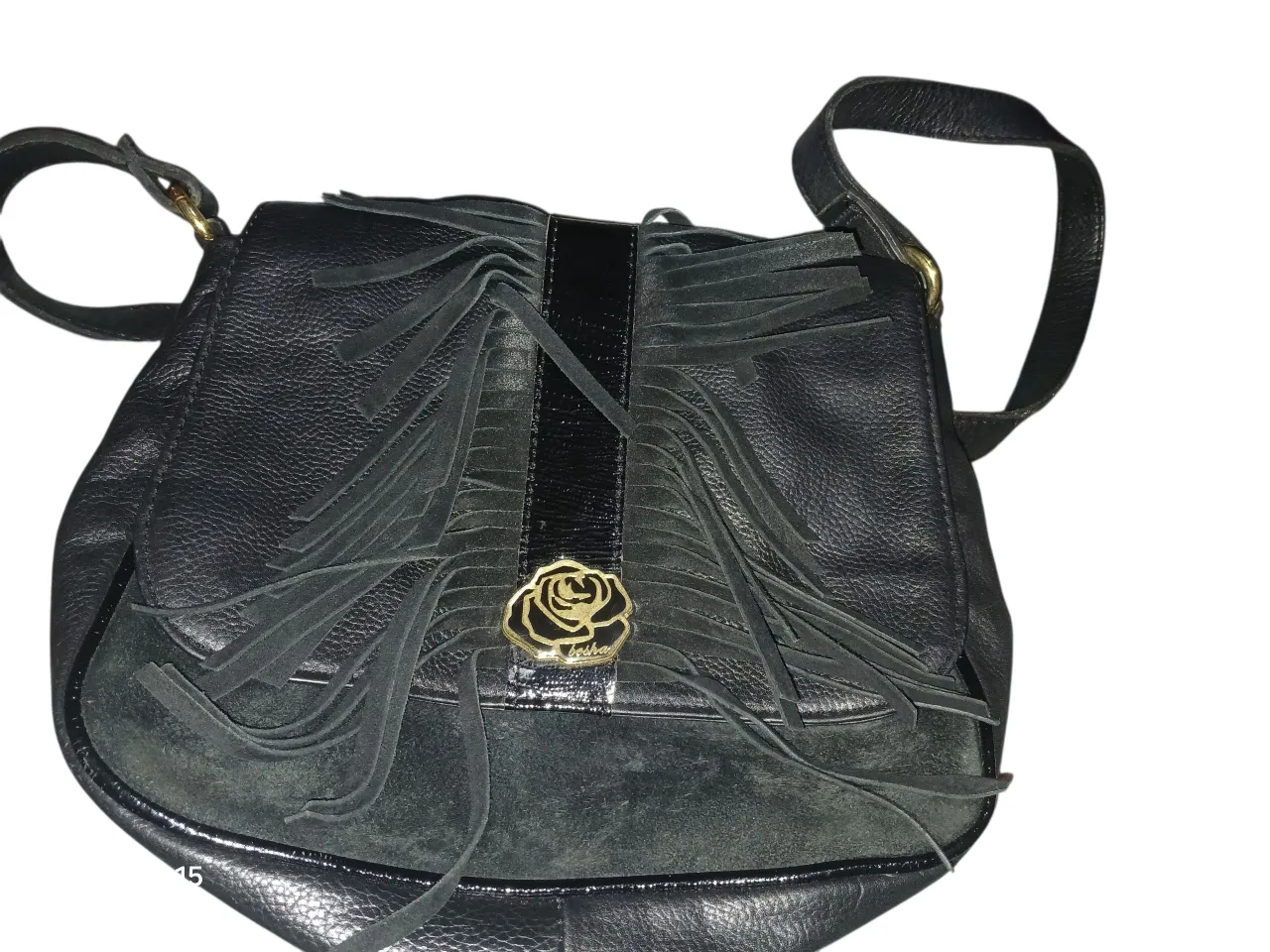 Cartera bandolera negra con flecos y detalle de flor dorada. Ideal para un look casual y con estilo.