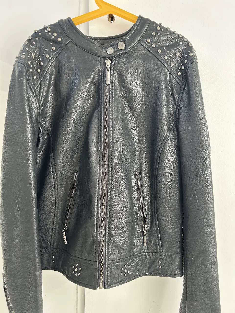 Campera de cuero sintético negra con tachas plateadas. Diseño biker con cierre y bolsillos con cierre. Detalles de tachas en hombros, espalda y frente. Ideal para un look rocker y canchero.