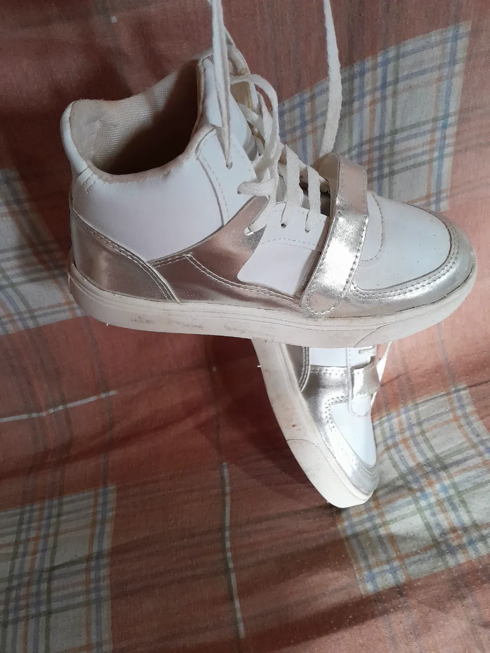 Zapatillas blancas con detalles plateados y cierre de velcro, ideales para niñas. Diseño moderno y cómodo para el día a día.