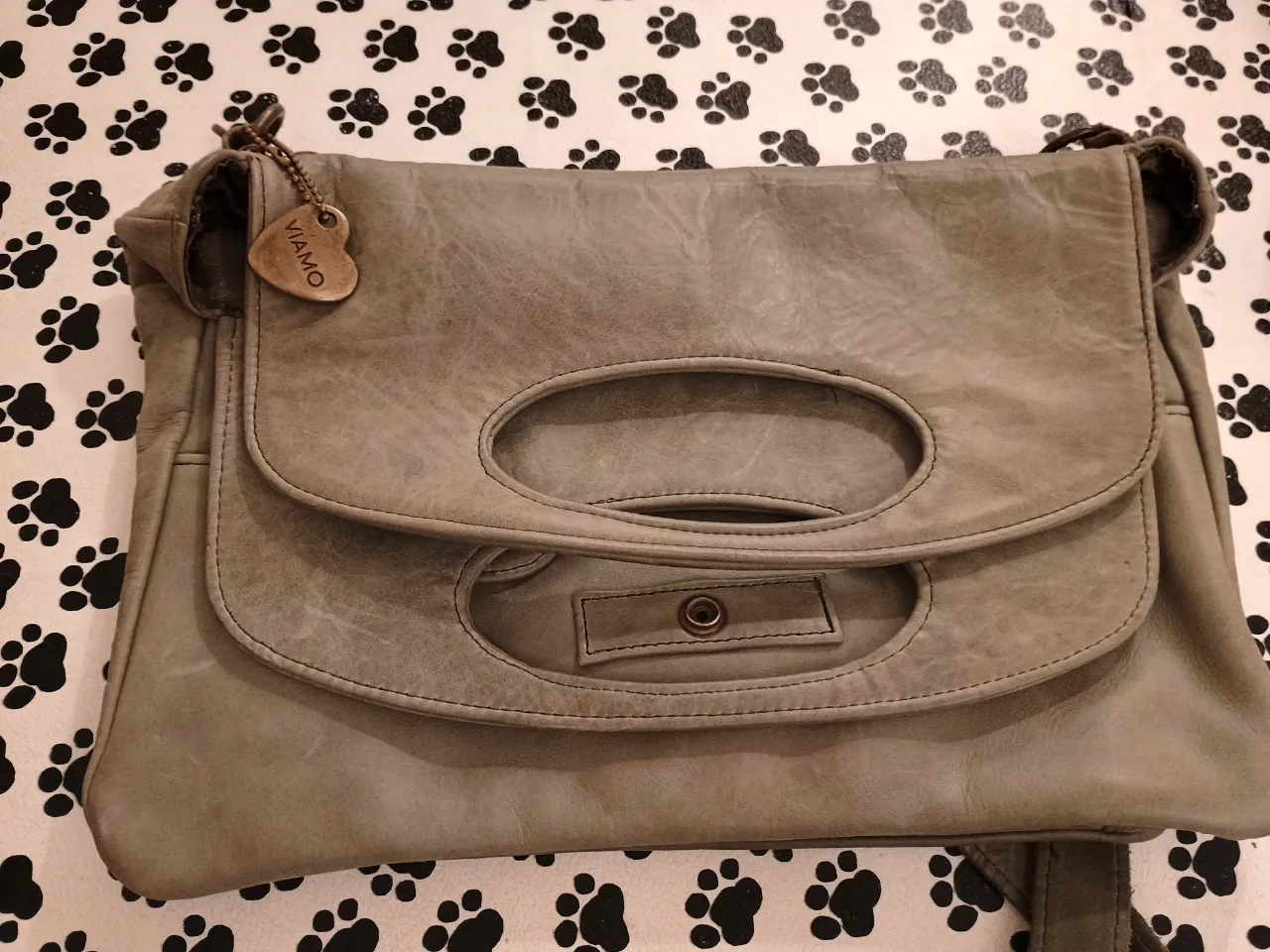 Cartera de hombro de cuero gris con solapa y detalle de asa. Ideal para uso diario, con un estilo casual y versátil.