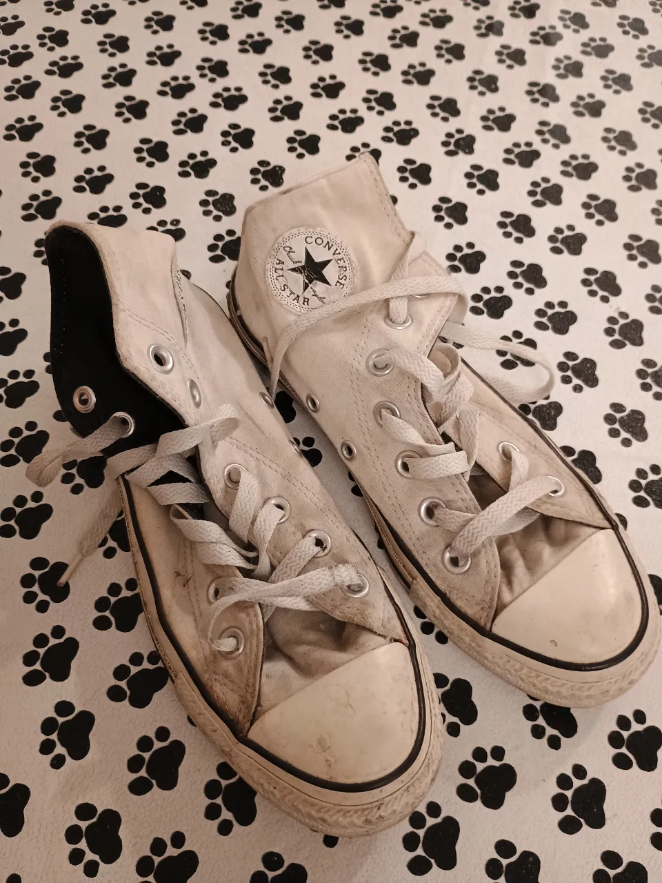 Zapatillas Converse All Star blancas de lona, caña alta, con detalles de uso y desgaste. Tienen la etiqueta de la marca en la lengüeta y en el talón. Talle 36.5.