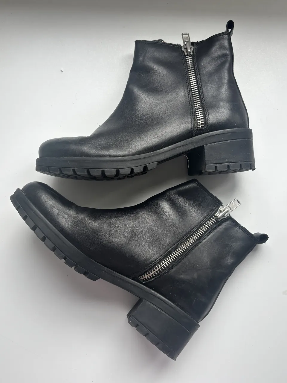 Botitas negras Urban Outfitters, de cuero con cierre metálico lateral y suela gruesa.