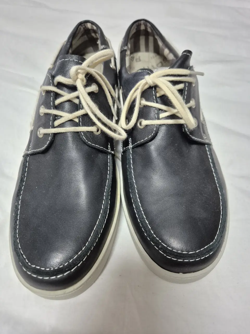 Náuticos de cuero negro con detalles en blanco y cordones. Ideales para un look casual y cómodo. La marca es Pasotti.