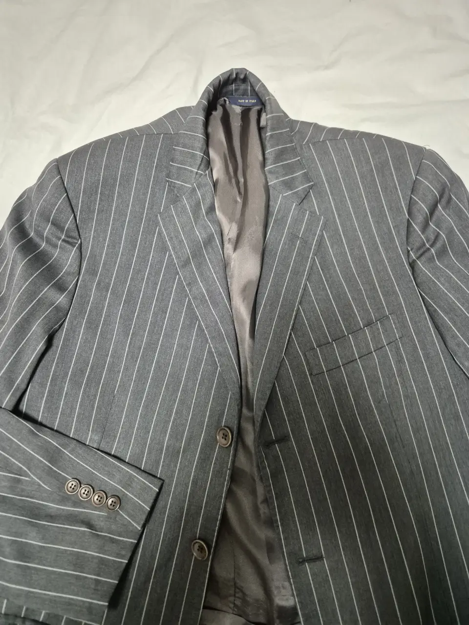 Elegante blazer gris con rayas blancas, ideal para un look formal o de trabajo. Confeccionado por Brooks Brothers, este saco sastrero ofrece un ajuste impecable y un estilo clásico.
