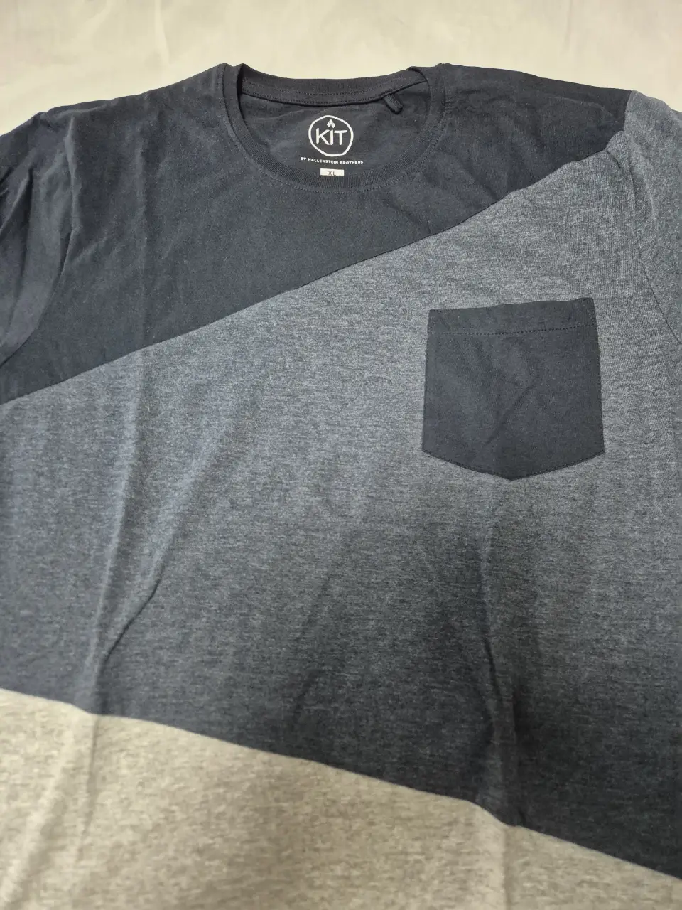 Remera KIT Australia de hombre con diseño en dos tonos, azul y gris. Corte recto, con bolsillo en el pecho y cuello redondo. Ideal para un look casual y cómodo.
