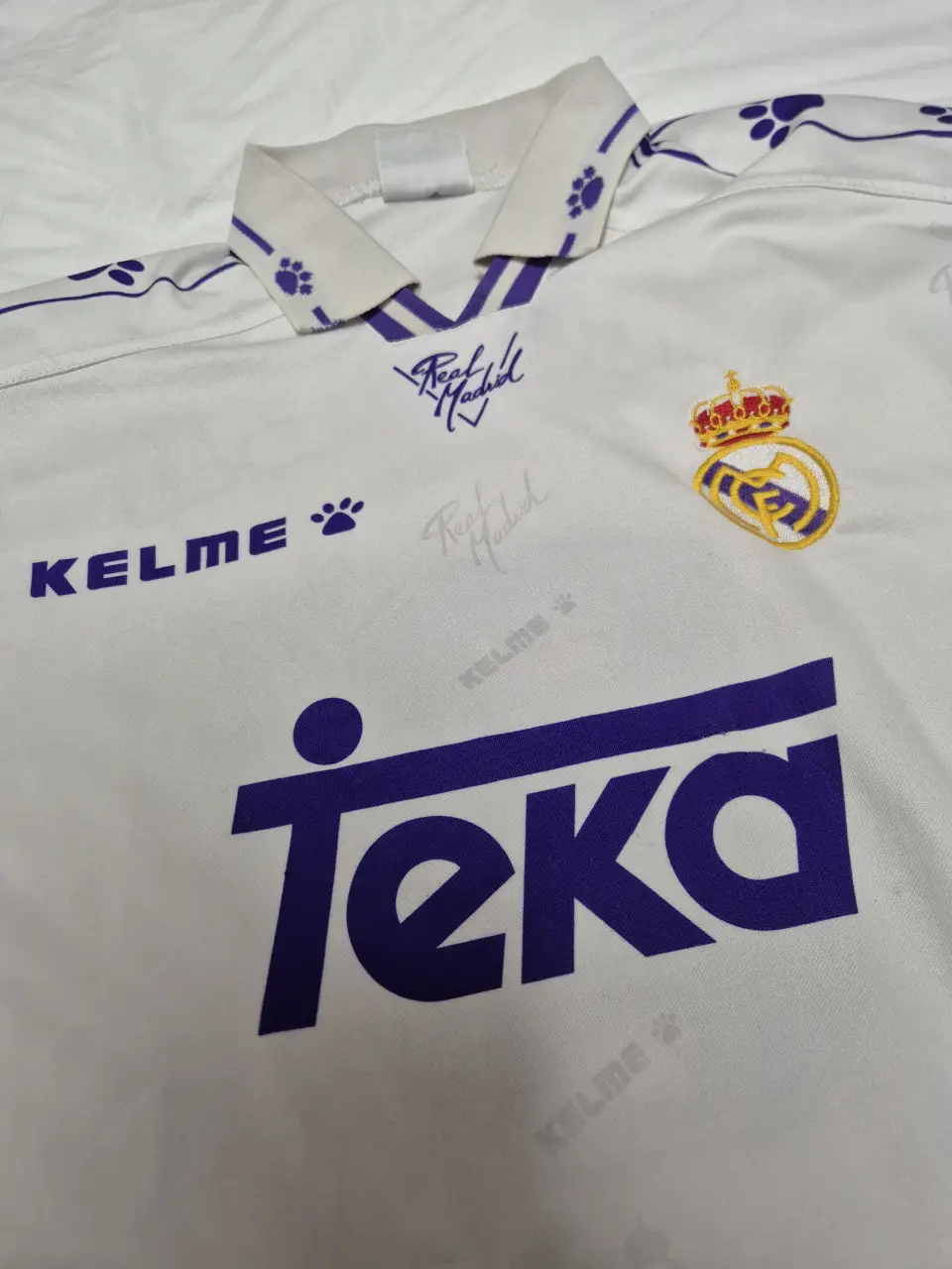 Camiseta Kelme Real Madrid 1994/96, talle M. Blanca con detalles en azul y el logo de Teka. Ideal para coleccionistas y fanáticos del fútbol.