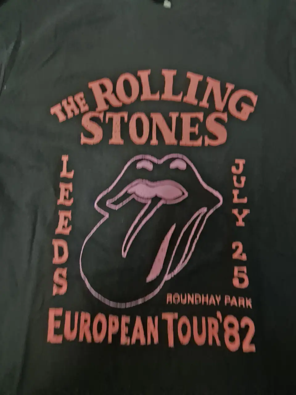 Remera negra de hombre con estampado de The Rolling Stones y logo de la banda. Diseño vintage con la lengua icónica y detalles de la gira europea de 1982. Ideal para un look rocker y casual.