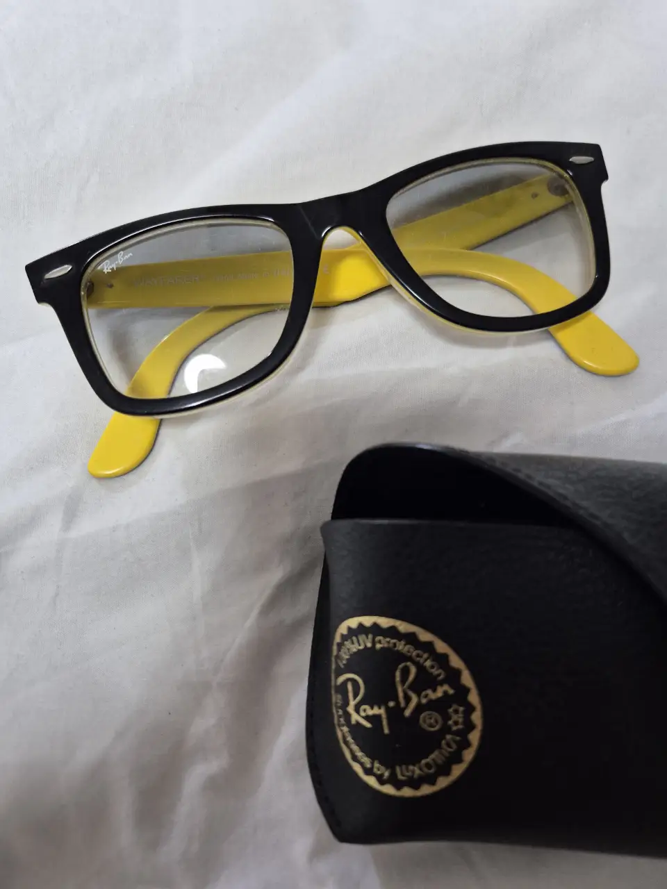 Anteojos Ray-Ban Wayfarer con armazón negro y patillas amarillas. Incluye estuche original.