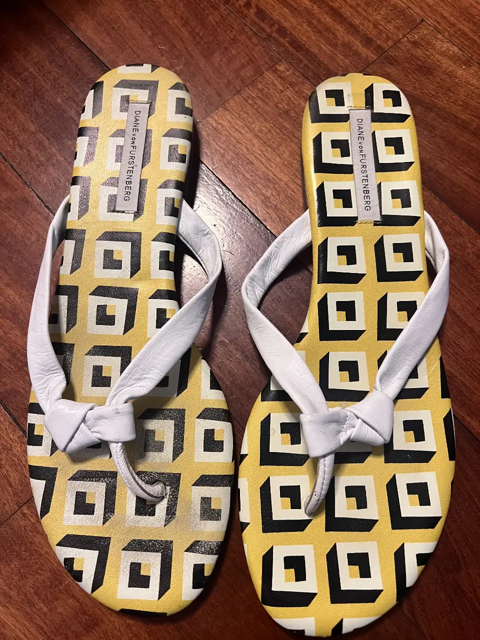 Sandalias Diane Von Furstenberg con estampado geométrico en amarillo y blanco, con tiras blancas y detalle de nudo. Talle 10M.