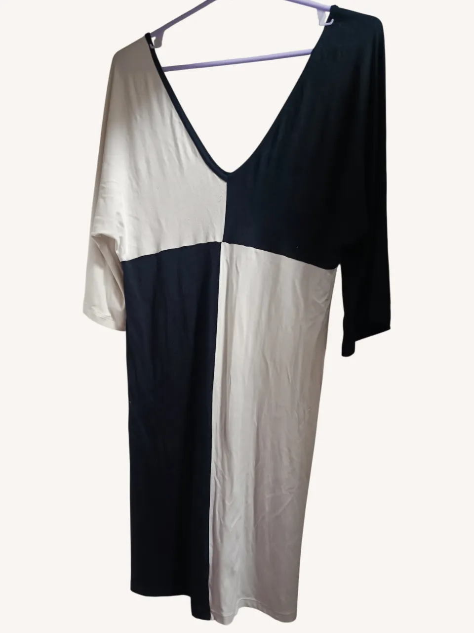 Vestido corto de mangas 3/4, con un diseño de bloques de color en blanco y negro. Escote en V pronunciado. Ideal para un look casual y moderno.