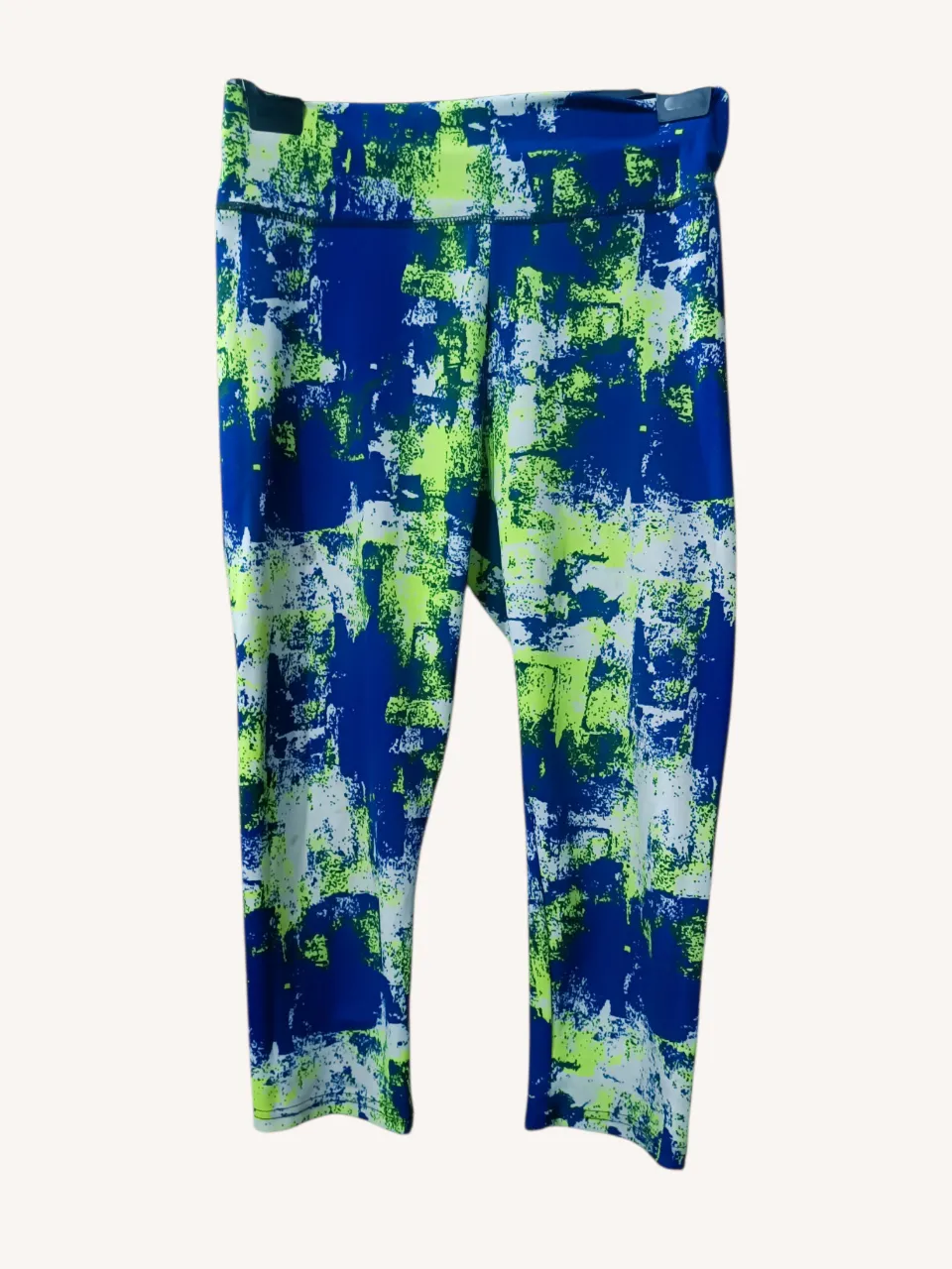 Calza deportiva capri con un estampado abstracto vibrante en azul, verde lima y blanco. Perfectas para entrenar o para un look casual y cómodo.