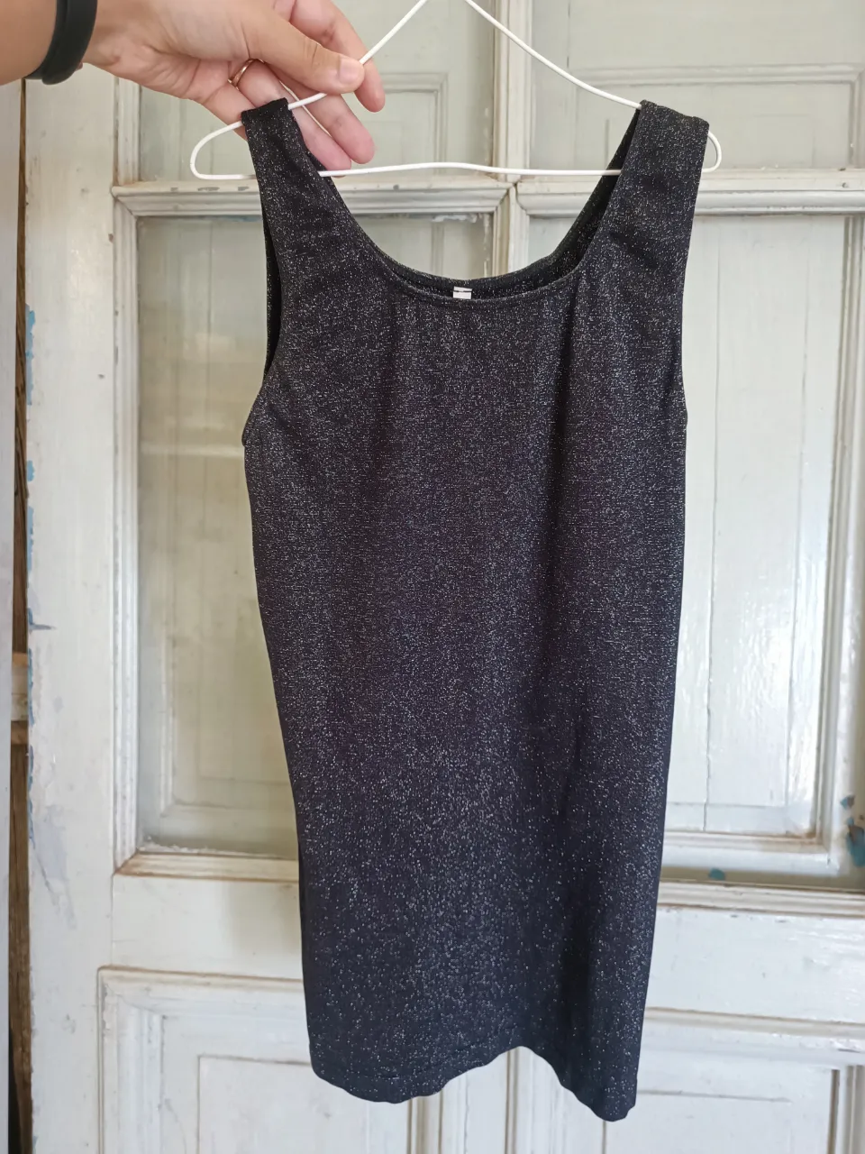 Musculosa negra con brillos plateados, ideal para un look canchero y moderno. Perfecta para combinar con jeans o faldas.