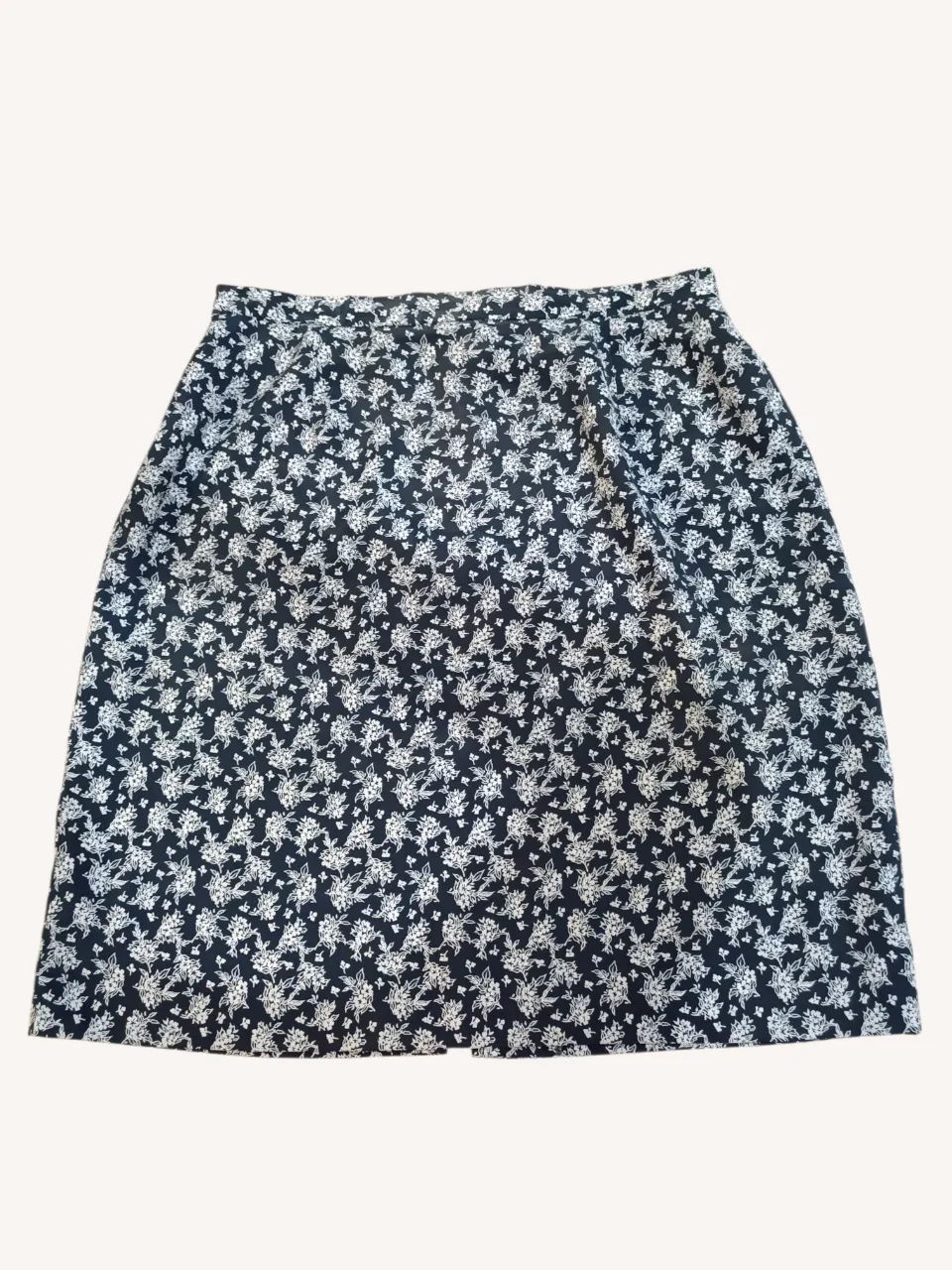 Pollera estampada con flores blancas sobre fondo azul oscuro. Posee cierre y un botón en la parte superior trasera.
📏 Cintura 37 cm.
Largo 51 cm.