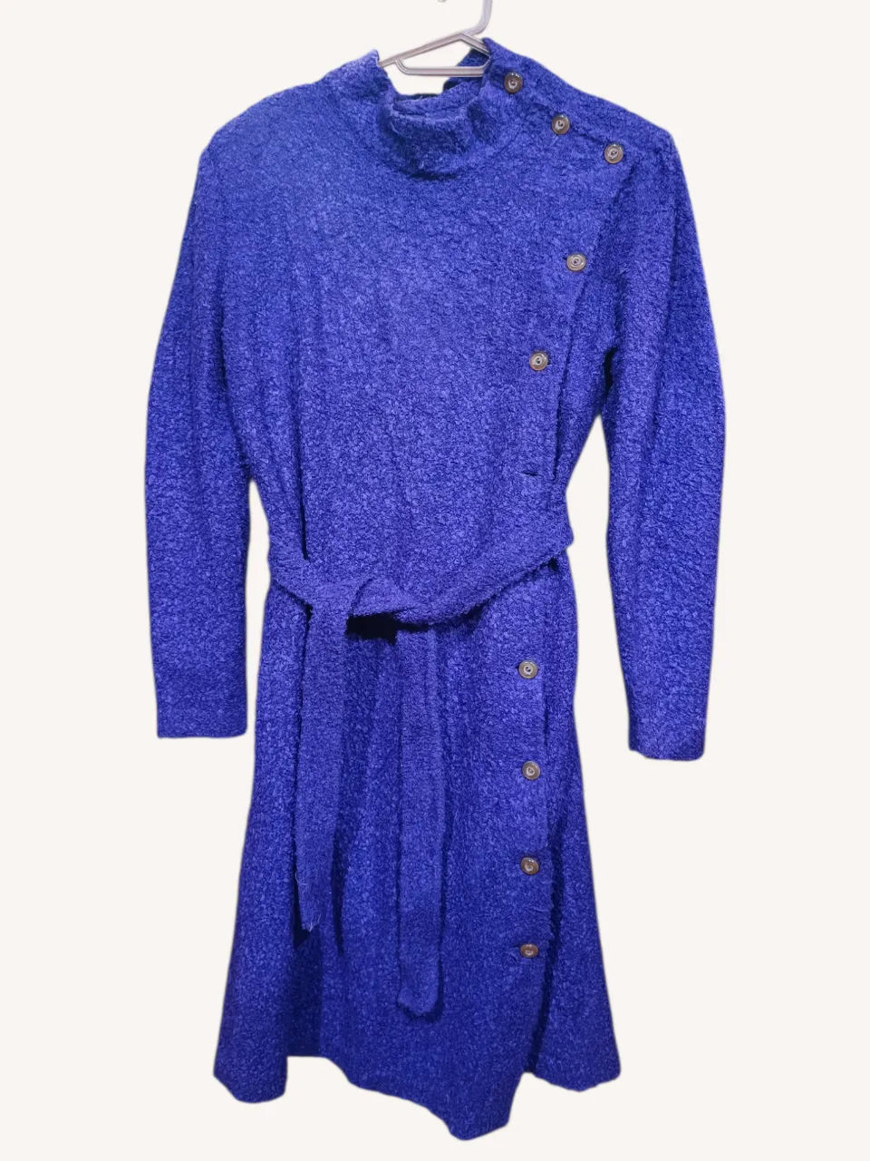 Vestido vintage de lana en color violeta vibrante, con cuello alto y detalles de botones en el frente. Incluye un cinturón del mismo material para ajustar a la cintura. Ideal para un look elegante y abrigado. Tiene hombreras.
📏 Ancho altura axilas: 50 cm. Largo: 105 cm. Manga 59 cm.
‼️Le falta un botón (ver fotos). 