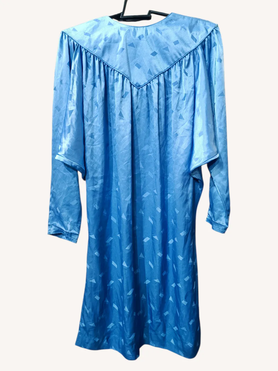 Vestido vintage azul con estampado geométrico y cuello redondo. Posee botones en la parte trasera del cuello.