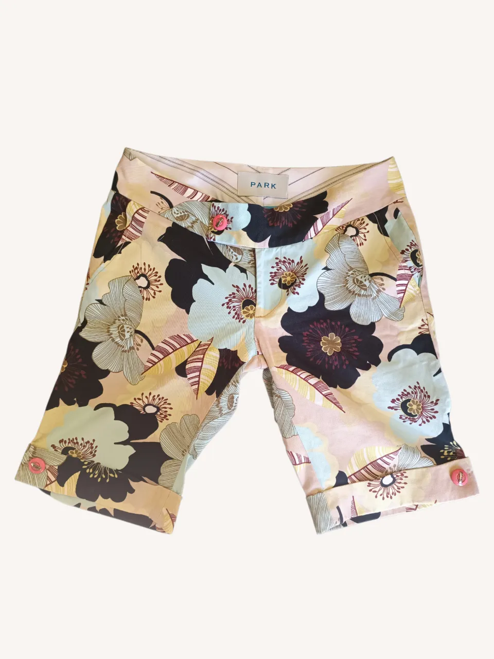 Shorts de vestir con estampado floral vibrante y colorido. Detalle de botones en los ruedos. Ideales para un look fresco y chic.