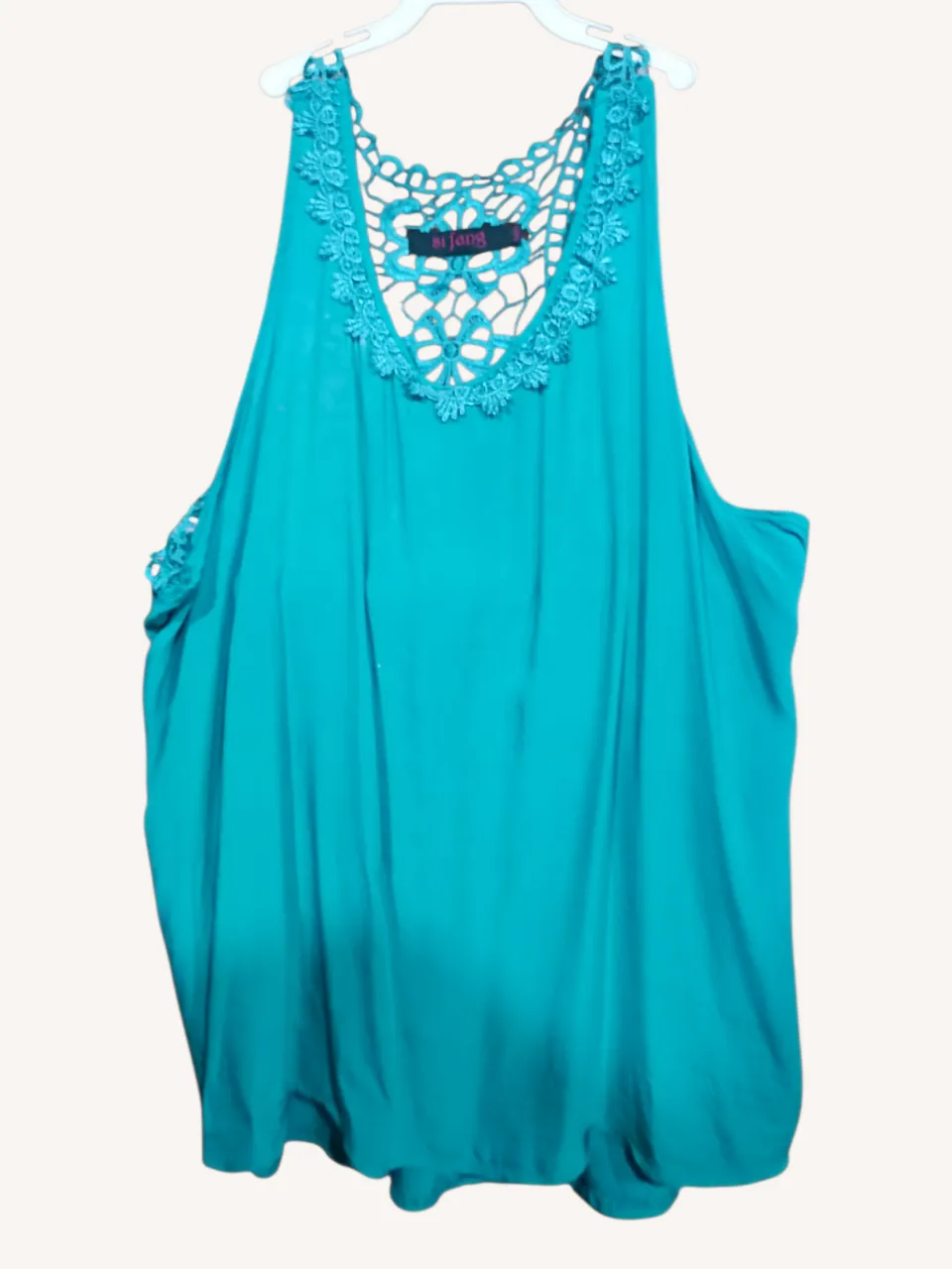 Musculosa de color turquesa con detalles de crochet en el cuello, espalda y hombros. Un diseño fresco y delicado, ideal para los días cálidos.