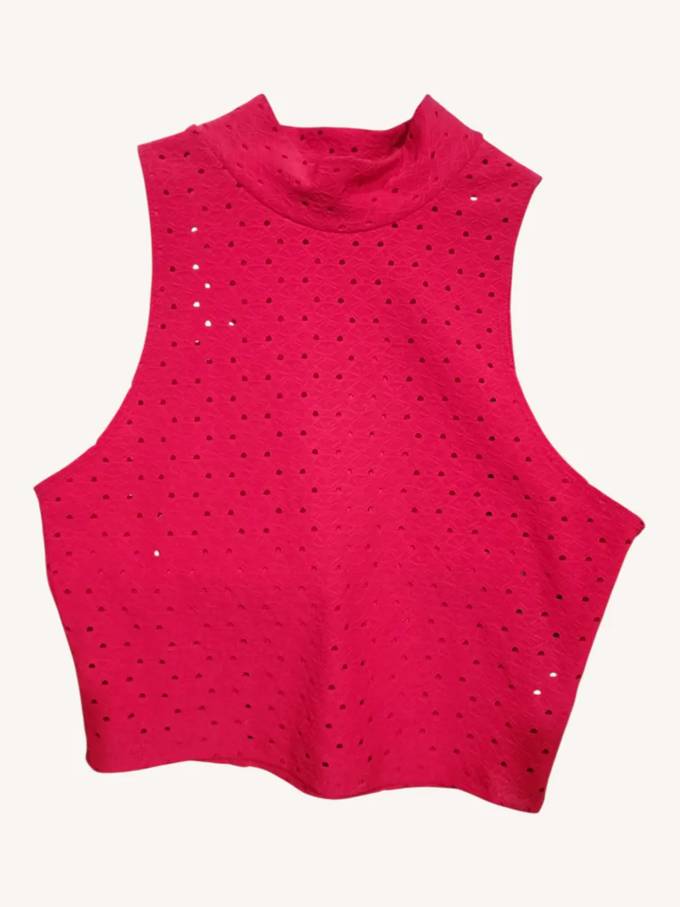 Top rojo escote alto con detalles de perforaciones. Ideal para un look canchero y fresco.