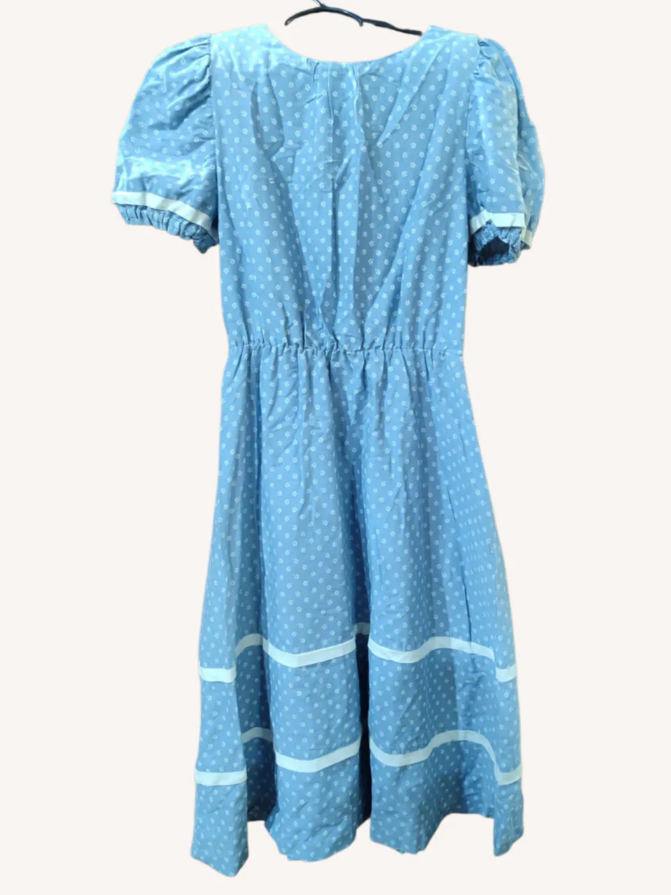 Vestido vintage azul claro con estampa de flores blancas y detalles de cintas blancas. Tiene mangas cortas abullonadas y cintura. Ideal para un look casual y fresco.
‼️Prenda vintage. Tiene pequeñas hombreras.