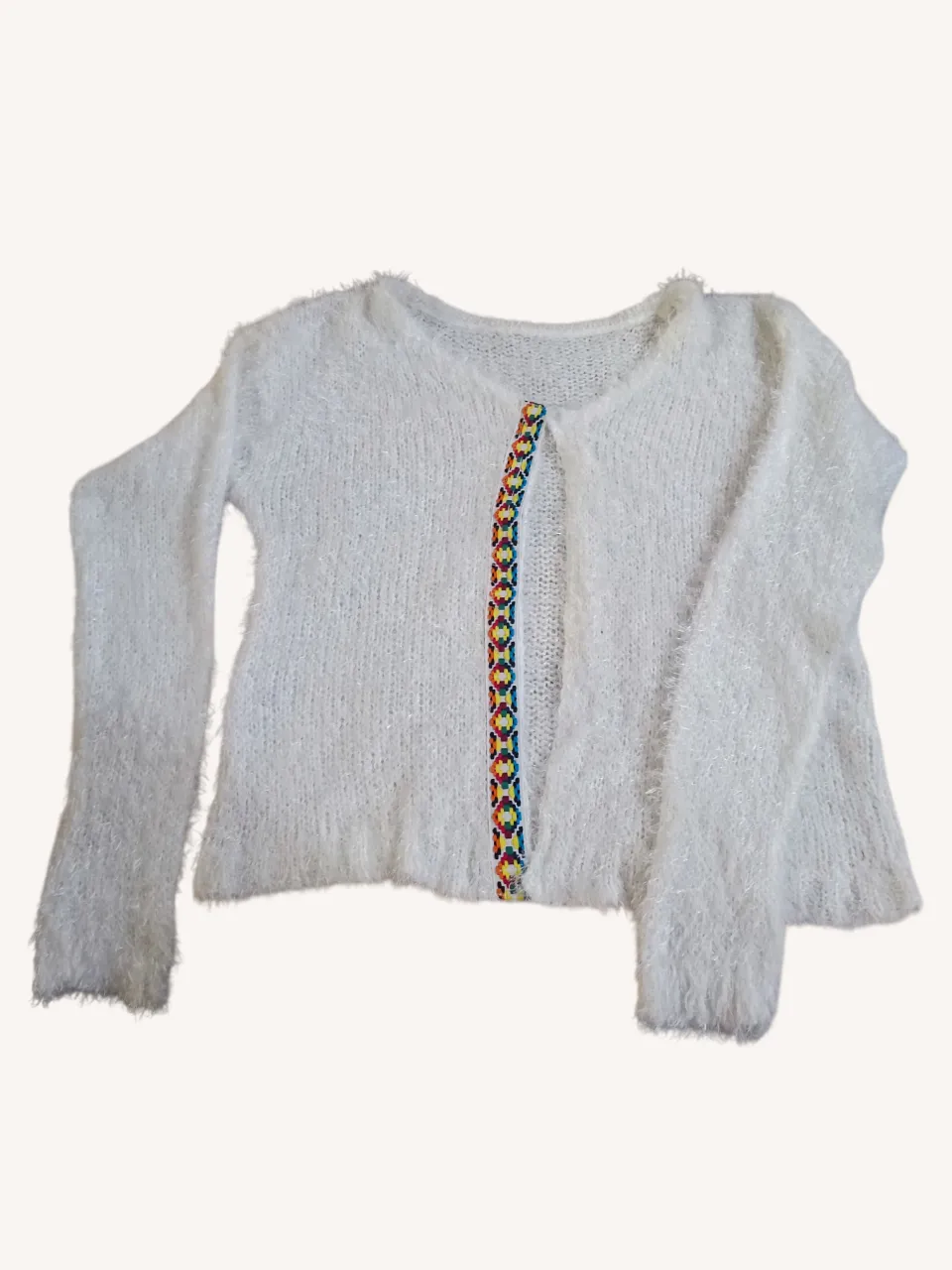 Cardigan blanco de hilo con detalles bordados en la parte delantera. Ideal para un look comfy y canchero.