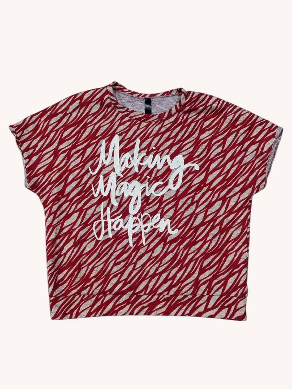 Remera estampada con diseño de cebra en rojo y gris. Posee un estampado de "Making Magic Happen" en blanco en el frente. Ideal para un look casual y divertido.
Tela gruesa ideal para media estación.